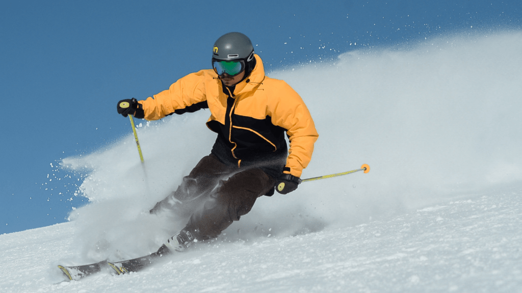 man wearing yellow black jacket skiing