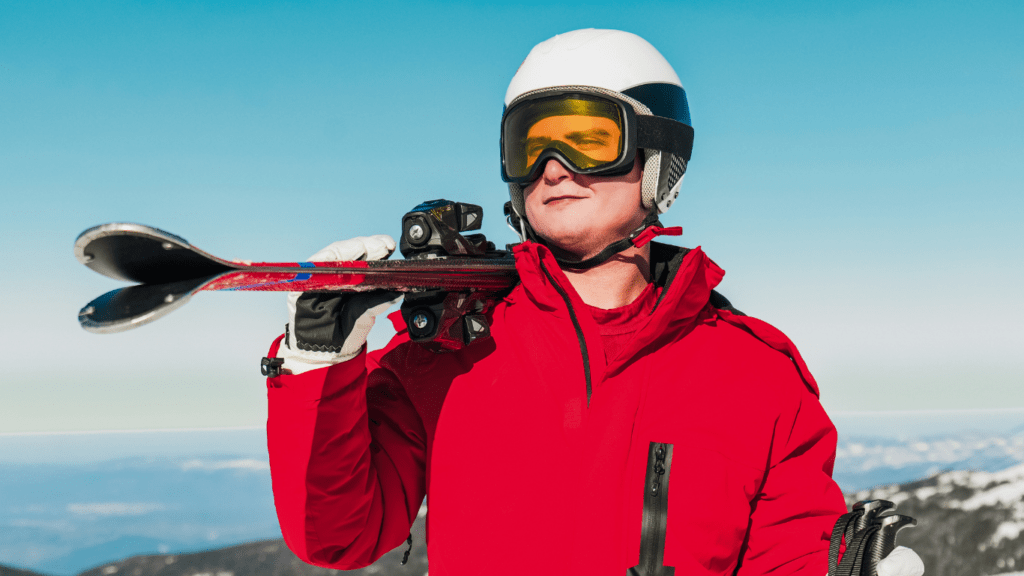 man holding ski equipments