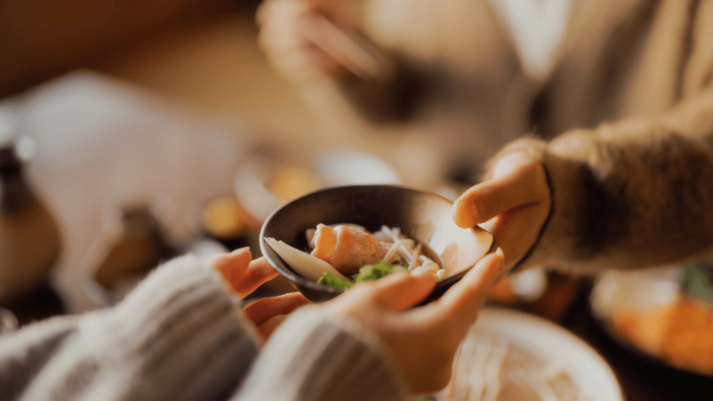 woman handing dish to a woman